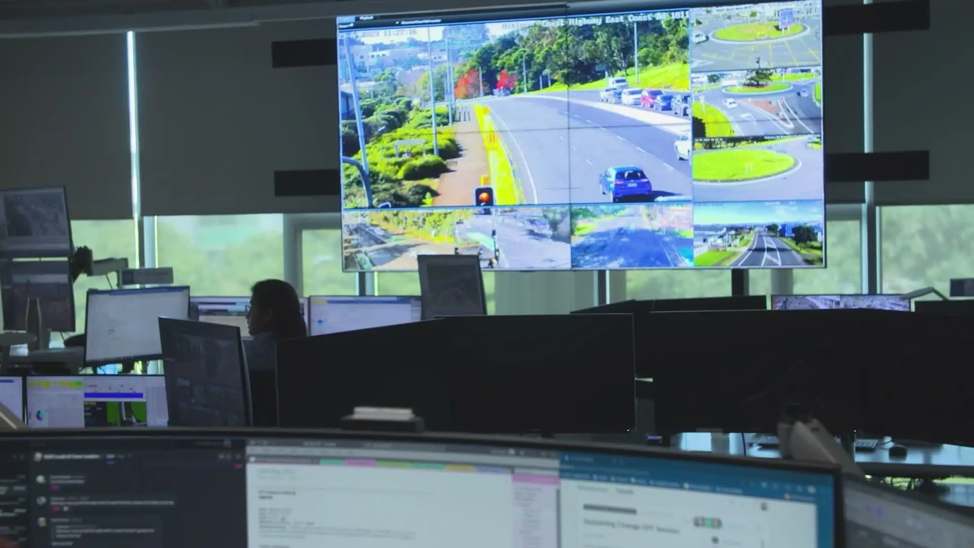 An operations control room with a wall of screens and staff at their desks.
